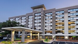 A multi-story hotel with a modern design, featuring a prominent entrance with a covered walkway and a sign that reads "SPRINGHILL SUITES BY MARRIOTT."