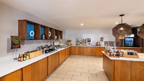 A modern kitchen with wooden cabinets, a white countertop, and a herringbone floor pattern.