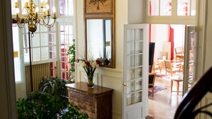 A spacious foyer with a wooden bench, a chandelier, and a door leading to a dining area. - Best Western Grand Hotel de Paris & Spa (Villard-de-Lans)