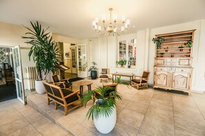 A spacious lobby with a chandelier, wooden furniture, and potted plants. - Best Western Grand Hotel de Paris & Spa (Villard-de-Lans)