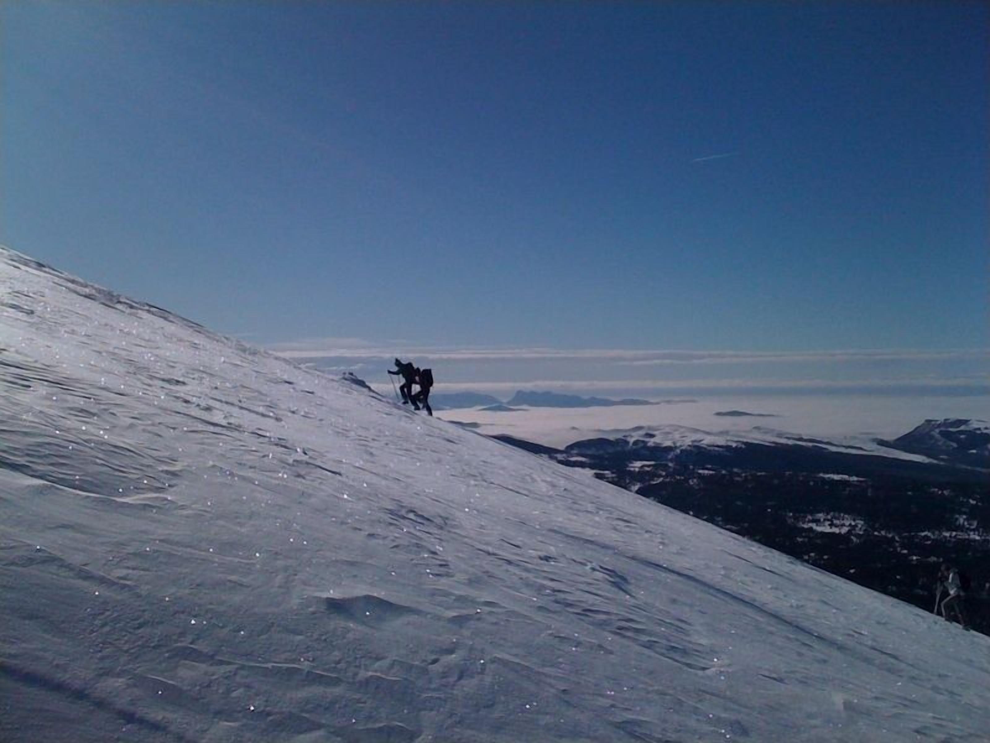 A snowy mountain slope with a clear sky.