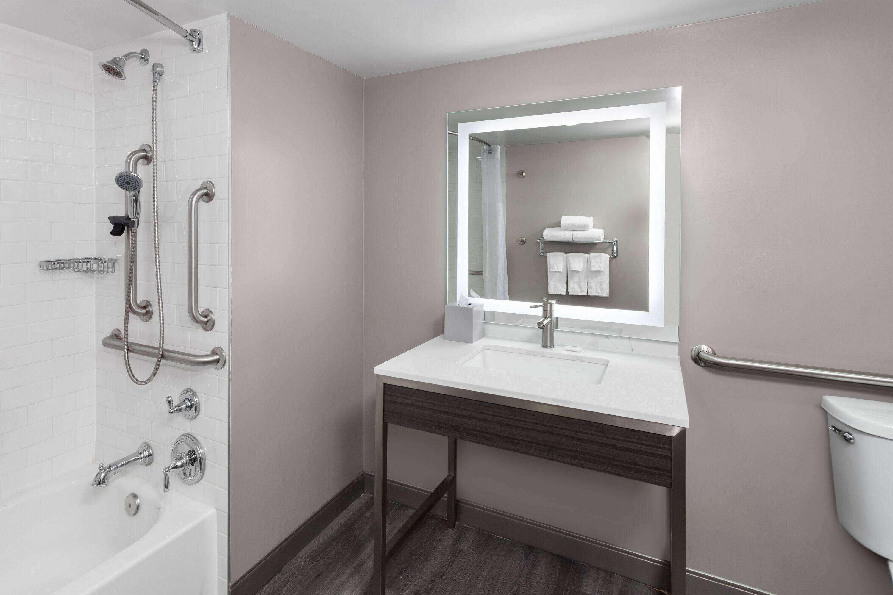 A modern bathroom with a shower, sink, and toilet.