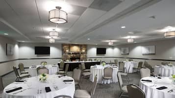 A conference room with multiple tables, chairs, and a stone fireplace.