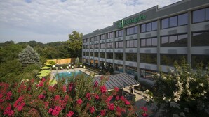 Een Holiday Inn hotel met een zwembad en weelderige begroeiing.