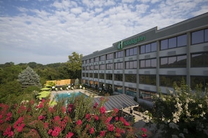 Ein Holiday Inn Hotel mit Pool und üppiger Bepflanzung.