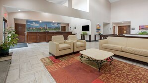 A spacious lobby with a reception desk, a large mural, and seating areas. - Best Western University Inn (Ithaca)