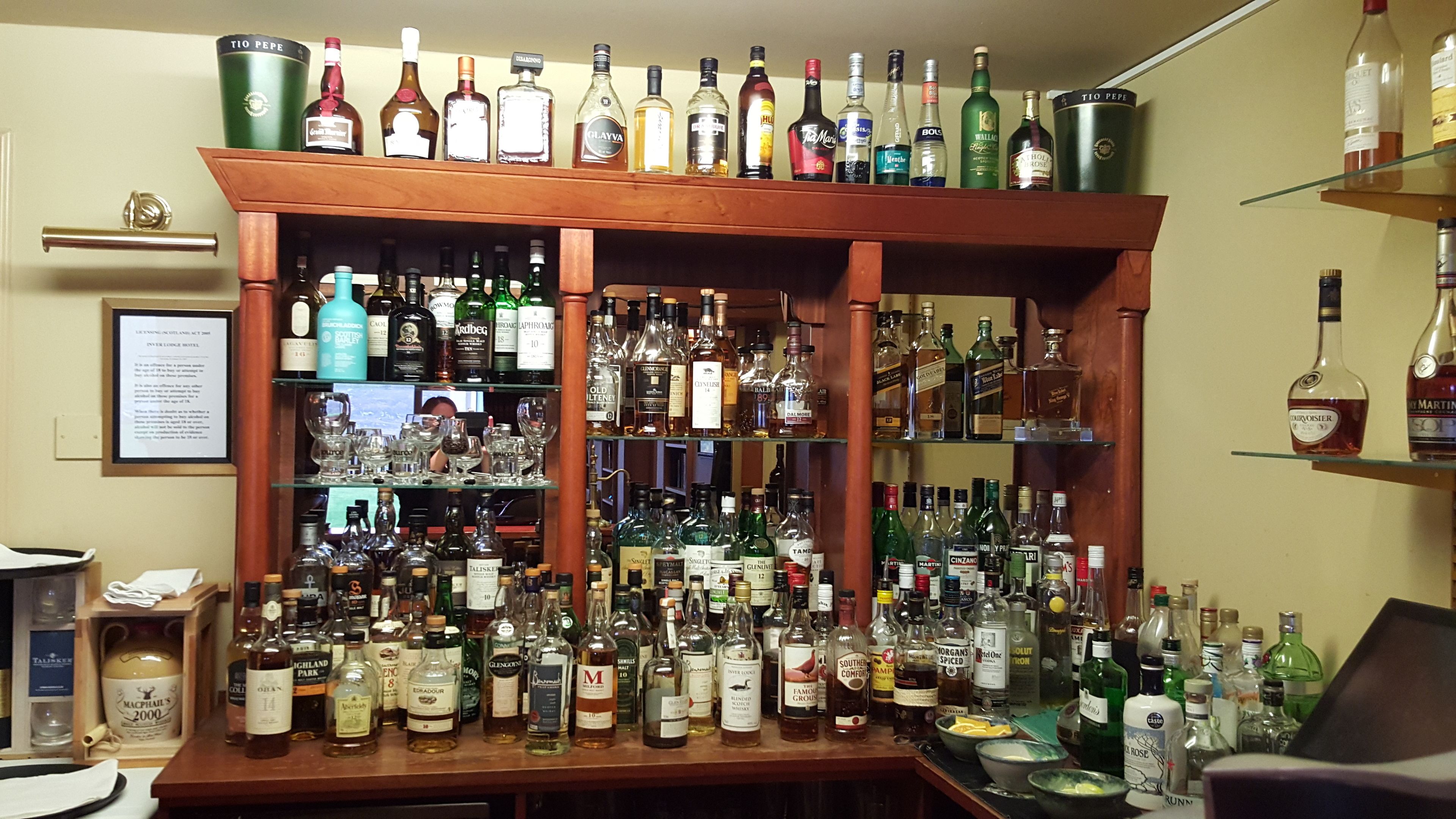 A bar area with shelves stocked with various liquor bottles.