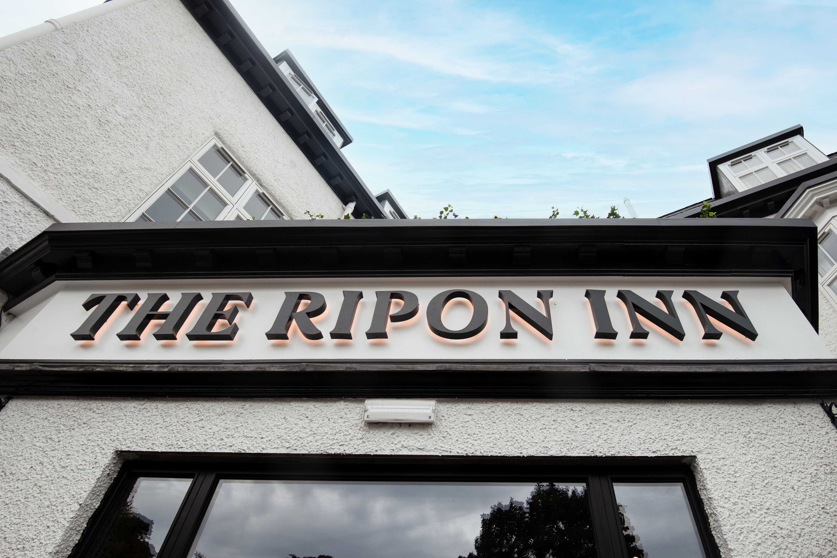 Fasaden på The Ripon Inn med en tydlig skylt ovanför ingången.