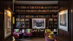 A library with bookshelves, a large framed picture, and seating areas. - Best Western Mornington Hotel London Hyde Park (London)