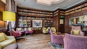 A library with bookshelves, a fireplace, and seating areas. - Best Western Mornington Hotel London Hyde Park (London)