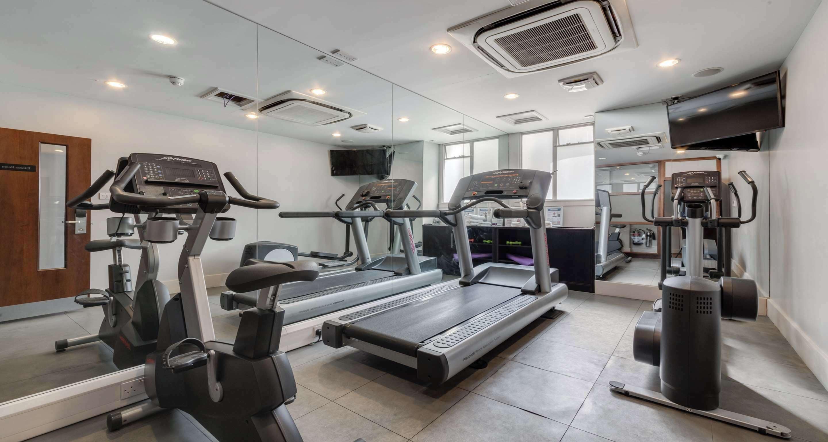 A gym with treadmills, elliptical machines, and a stationary bike.