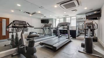 A gym with treadmills, elliptical machines, and a stationary bike.