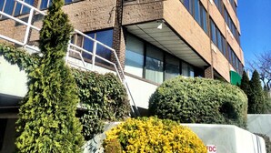 A multi-story building with a brick facade, large windows, and a flat roof. - Amsterdam Hotel (Stamford)