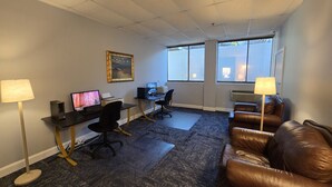 A furnished office space with a desk, computer, and a couch. - Amsterdam Hotel (Stamford)