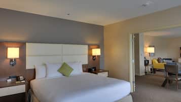 A hotel room with a large bed, bedside tables, a desk, and a chair.