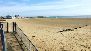 Une plage avec une rambarde en métal et une vue dégagée sur la mer.