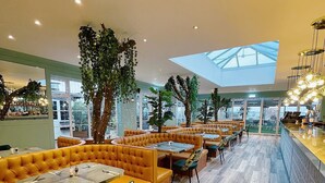 Un restaurant moderne avec des sièges rembourrés de couleur orange, un plancher en bois et de grandes fenêtres.