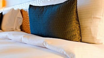 Una cama con ropa de cama blanca y un cabecero con diseño decorativo.