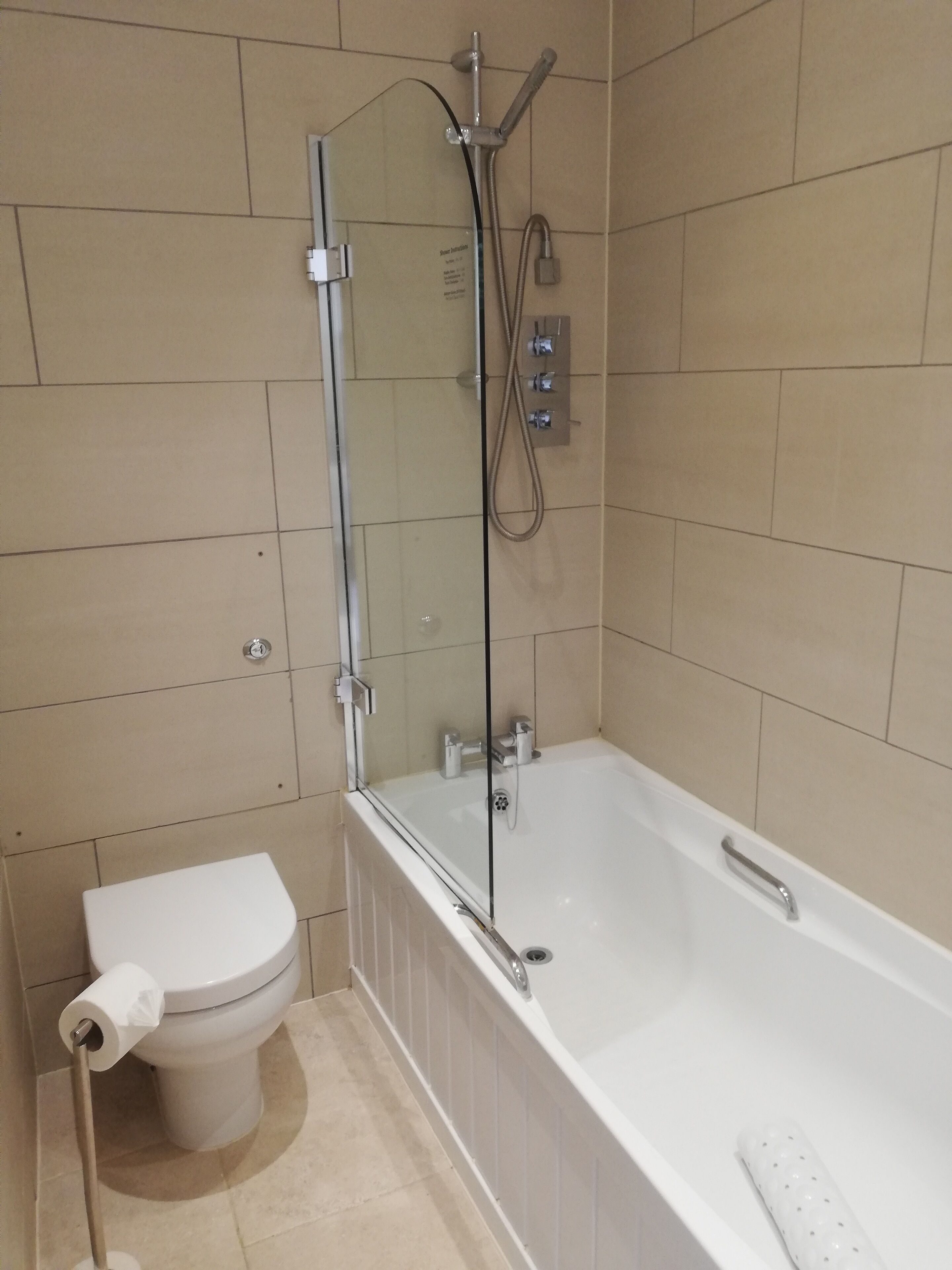 Ein Badezimmer mit Badewanne, Toilette und Duschkabine.