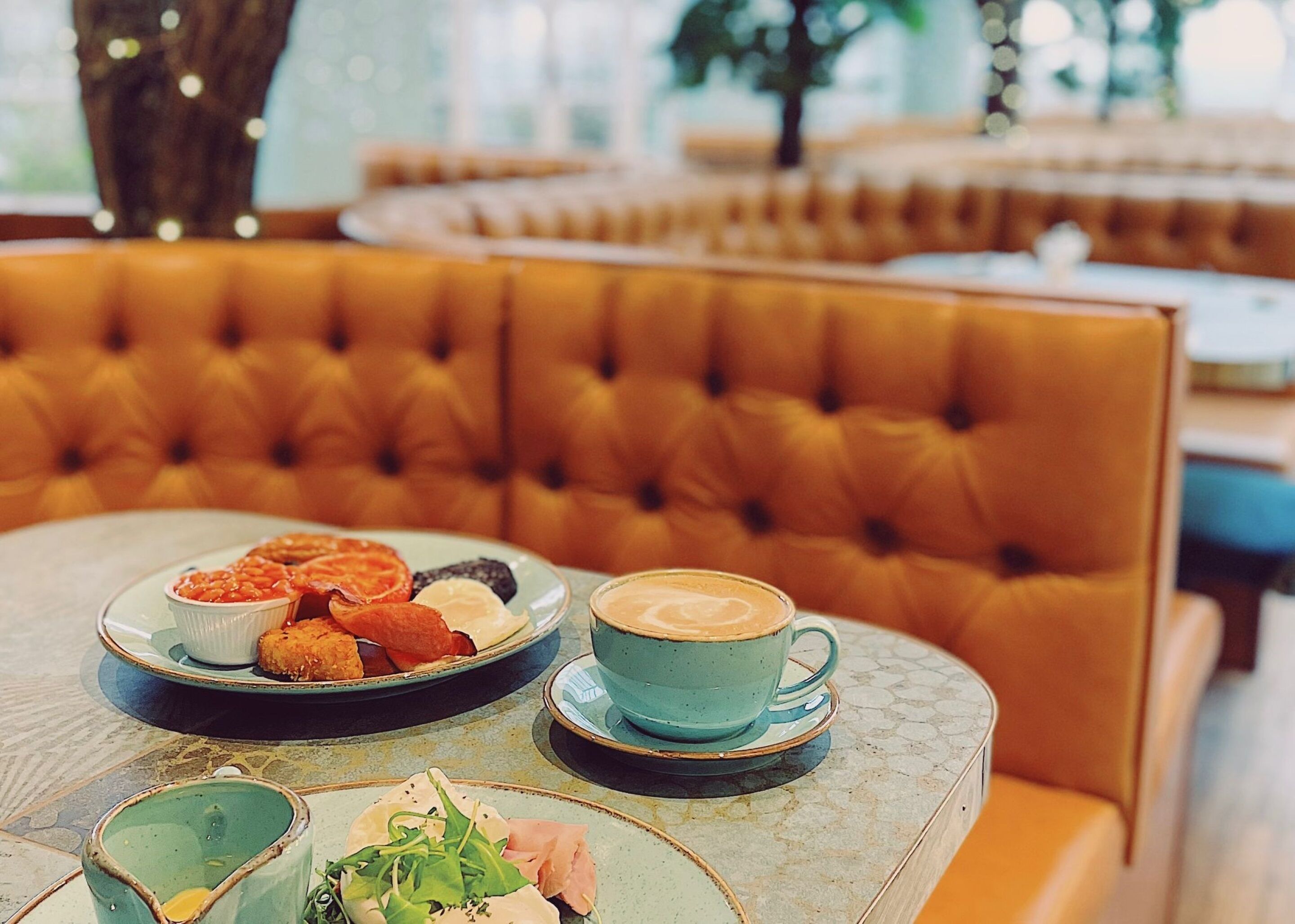 A table with a plate of pastries, a cup of coffee, and a small bowl of salad.