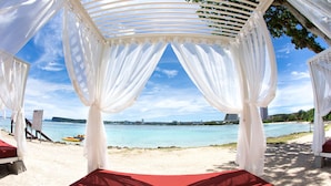 A beach cabana with a view of the sea and city skyline. - Hilton Guam Resort And Spa (Tamuning)