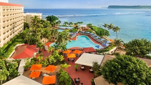 Un resort con piscina, mobiliario exterior y vistas al océano.