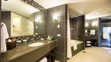 A modern bathroom with two sinks, a large mirror, and a shower area.