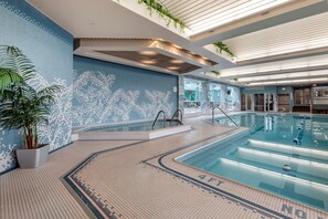 Una piscina techada, sillones reclinables de piscina