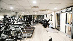 A gym with treadmills, elliptical machines, and free weights. - voco Telford - Ironbridge by IHG (Telford)