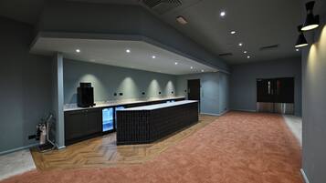 Een moderne keuken met een centraal eiland, inbouwapparatuur en een visgraatmotief houten vloer.
