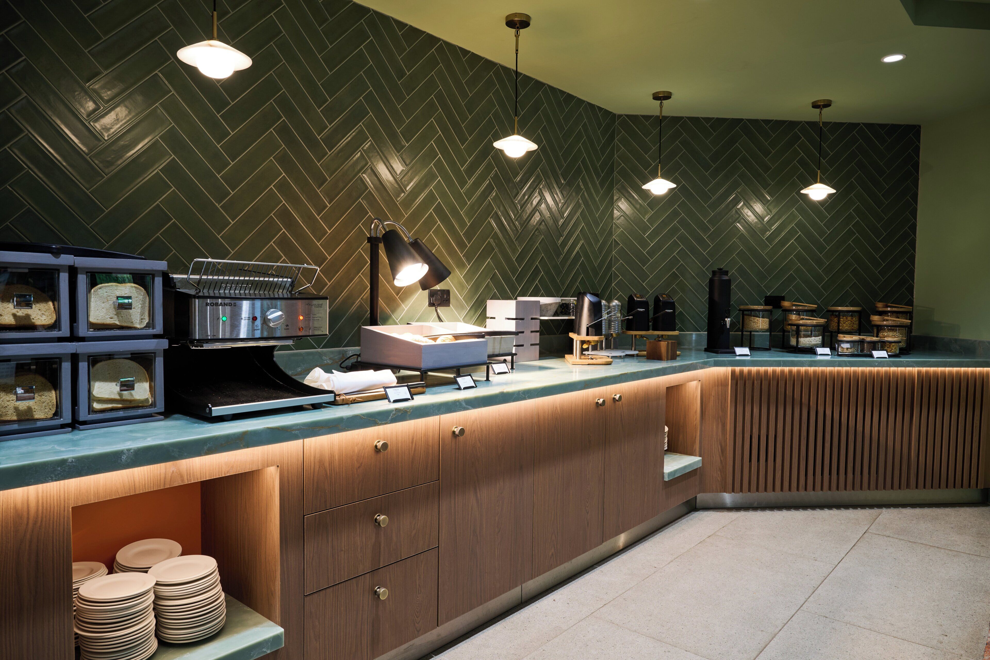 Una cocina moderna con salpicadero tipo espiga, armarios de madera y una estación de café integrada.