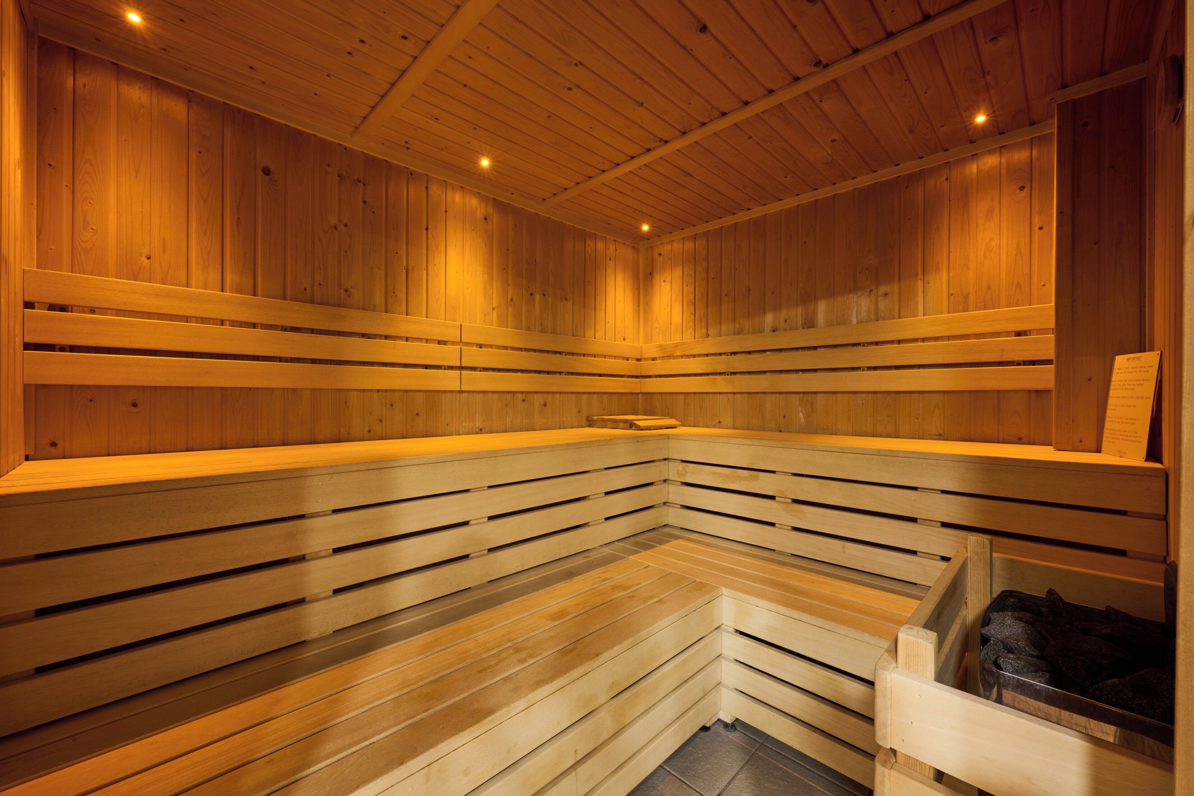 A sauna with wooden benches and a bench with a towel.