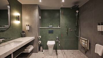Un baño moderno con un espejo grande, un lavabo, un inodoro y una ducha.