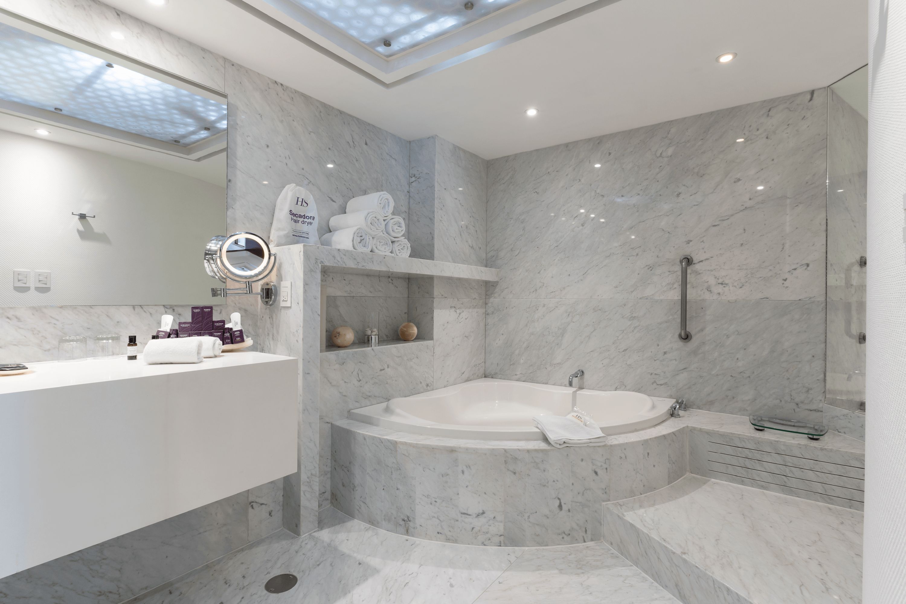Une salle de bain moderne avec une grande baignoire, un meuble-lavabo avec un miroir et un espace douche.
