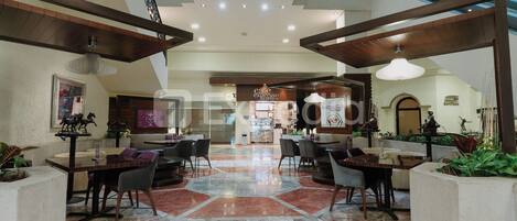 A spacious lobby with high ceilings, multiple seating areas, and a central open space.