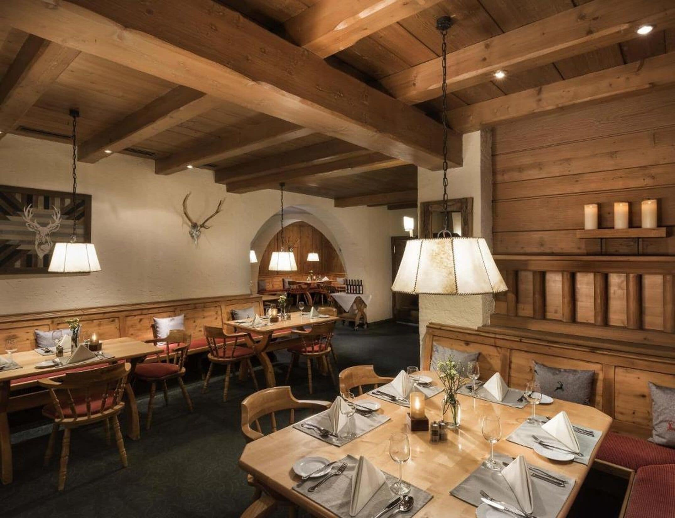 Un restaurante con vigas de madera, mesas dispuestas para comer y una decoración rústica.