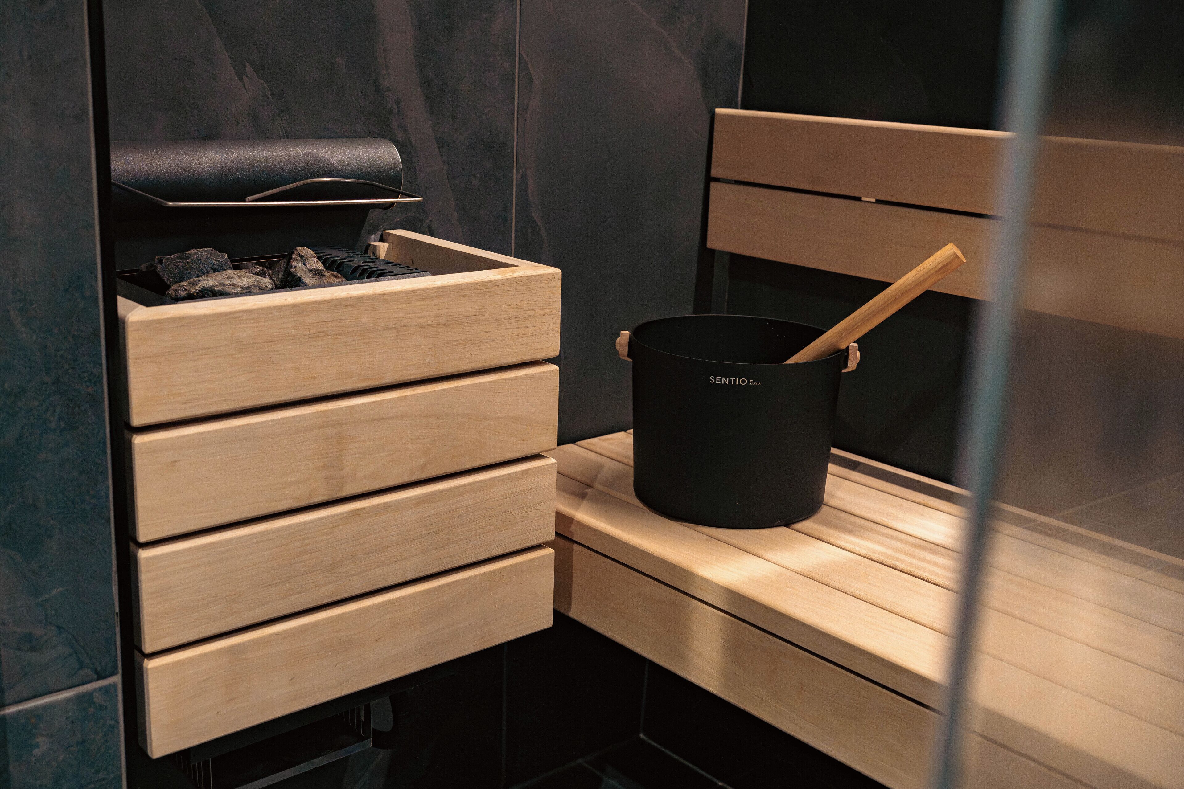 Una cocina moderna con estufa integrada, un mueble cajonero de madera y una olla negra con asa de madera sobre la encimera.