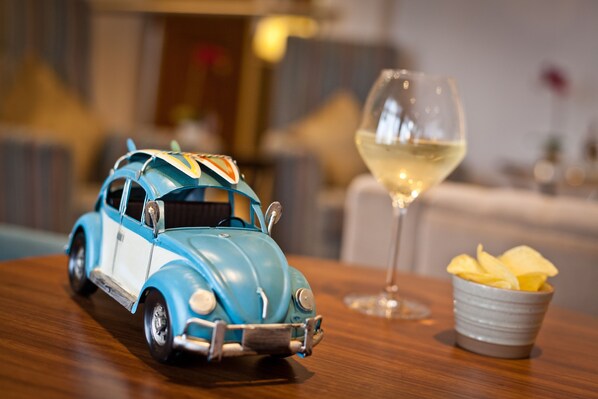 A toy car on a table with a glass of white wine and a bowl of chips. - Ambleside Salutation Hotel & Spa (Ambleside)