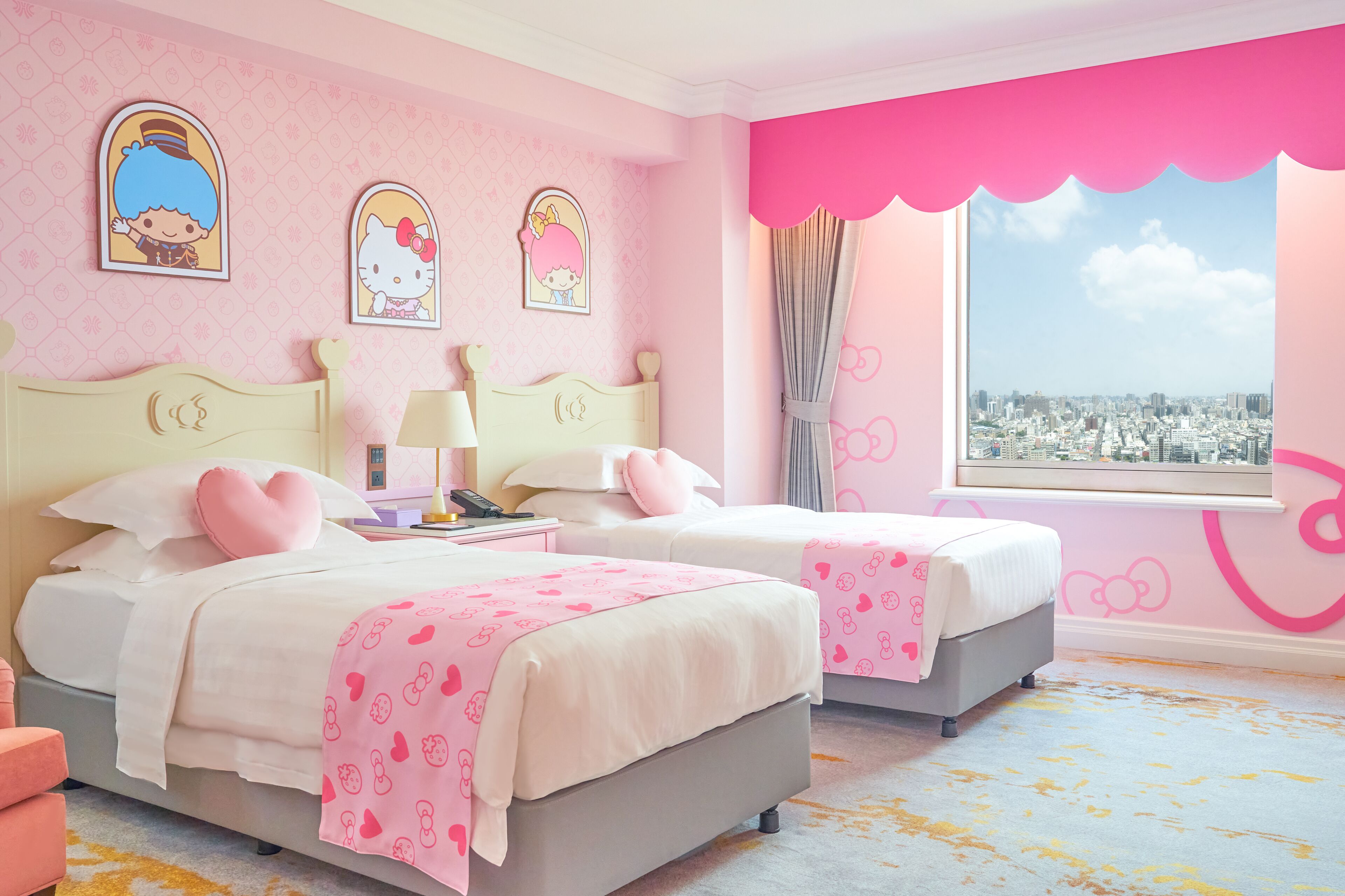 A pink-themed bedroom with two beds, a city view, and Hello Kitty decorations.