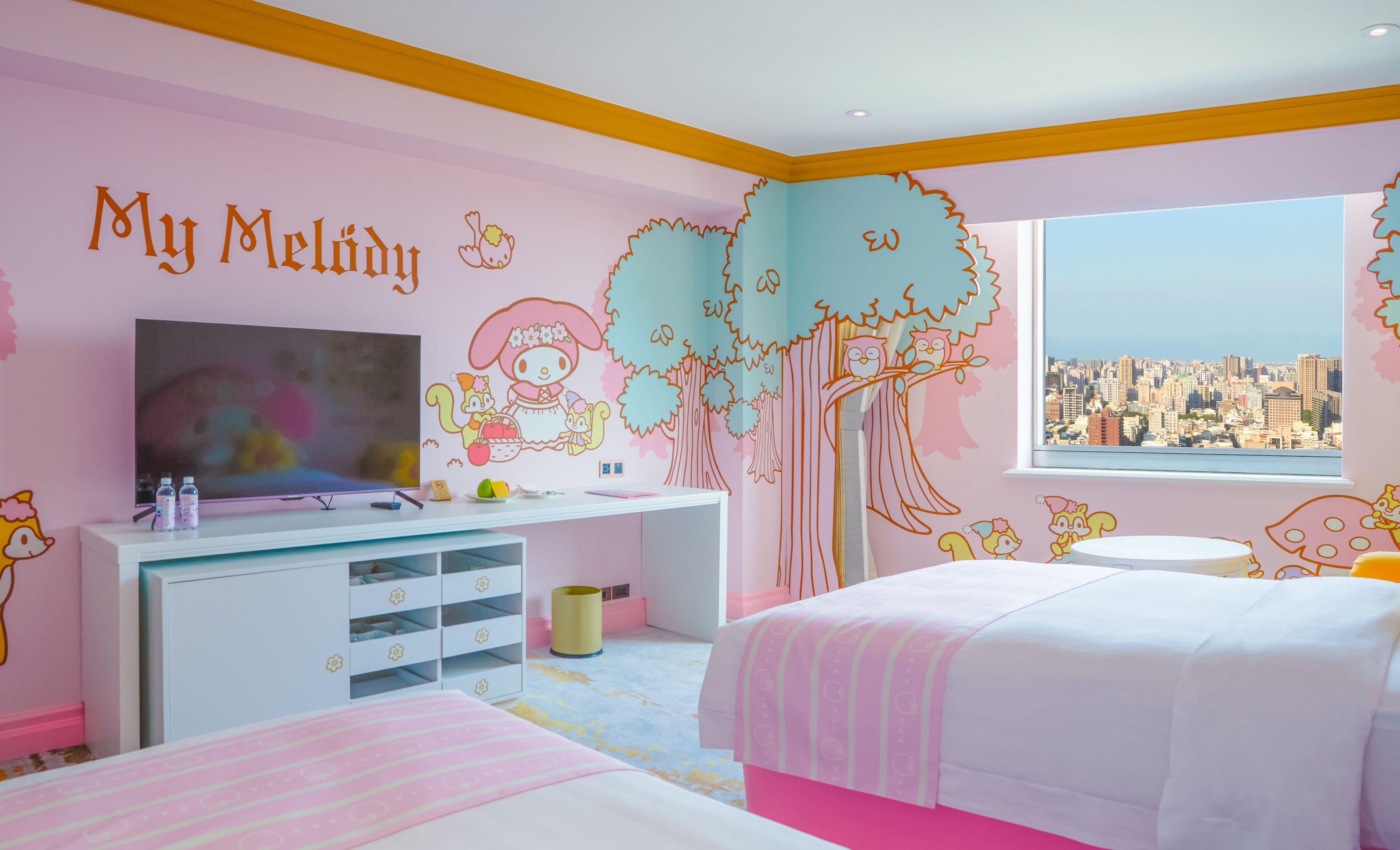 A child's bedroom with a city view, a TV, and a desk with storage drawers.