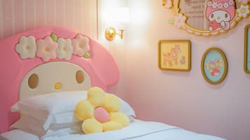 Camera da letto in tonalità rosa con testiera fiorata, lampada da comodino e decorazioni a parete tra cui quadri e uno specchio.