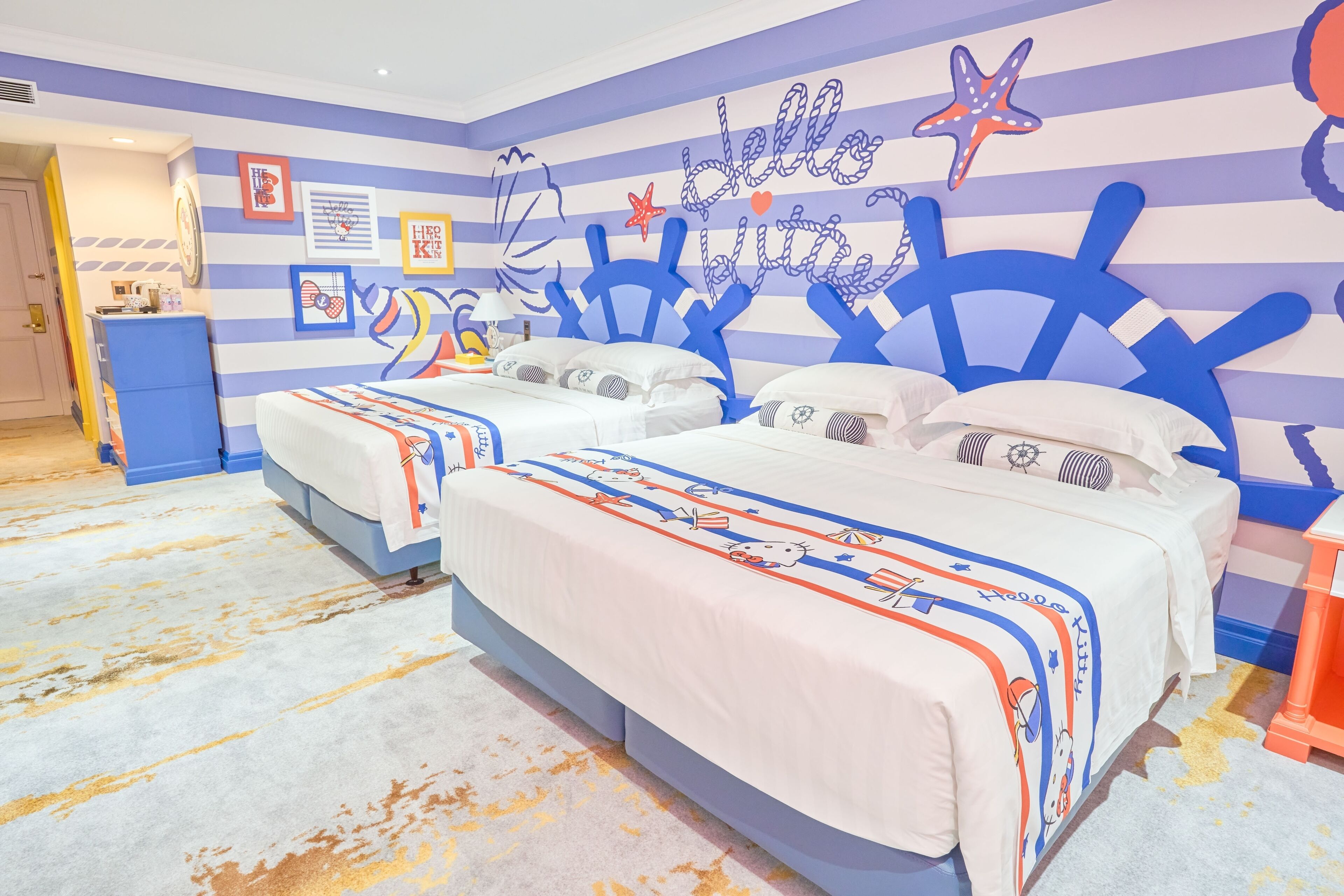 Una habitación con dos camas, paredes a rayas y decoración temática náutica.