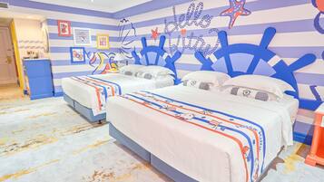 Una habitación con dos camas, paredes a rayas y decoración temática náutica.