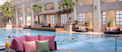 Una piscina al aire libre, sillones reclinables de piscina