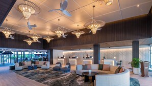 A spacious lobby with modern furniture, unique ceiling fans, and ambient lighting. - Tanoa International Hotel (Nadi)