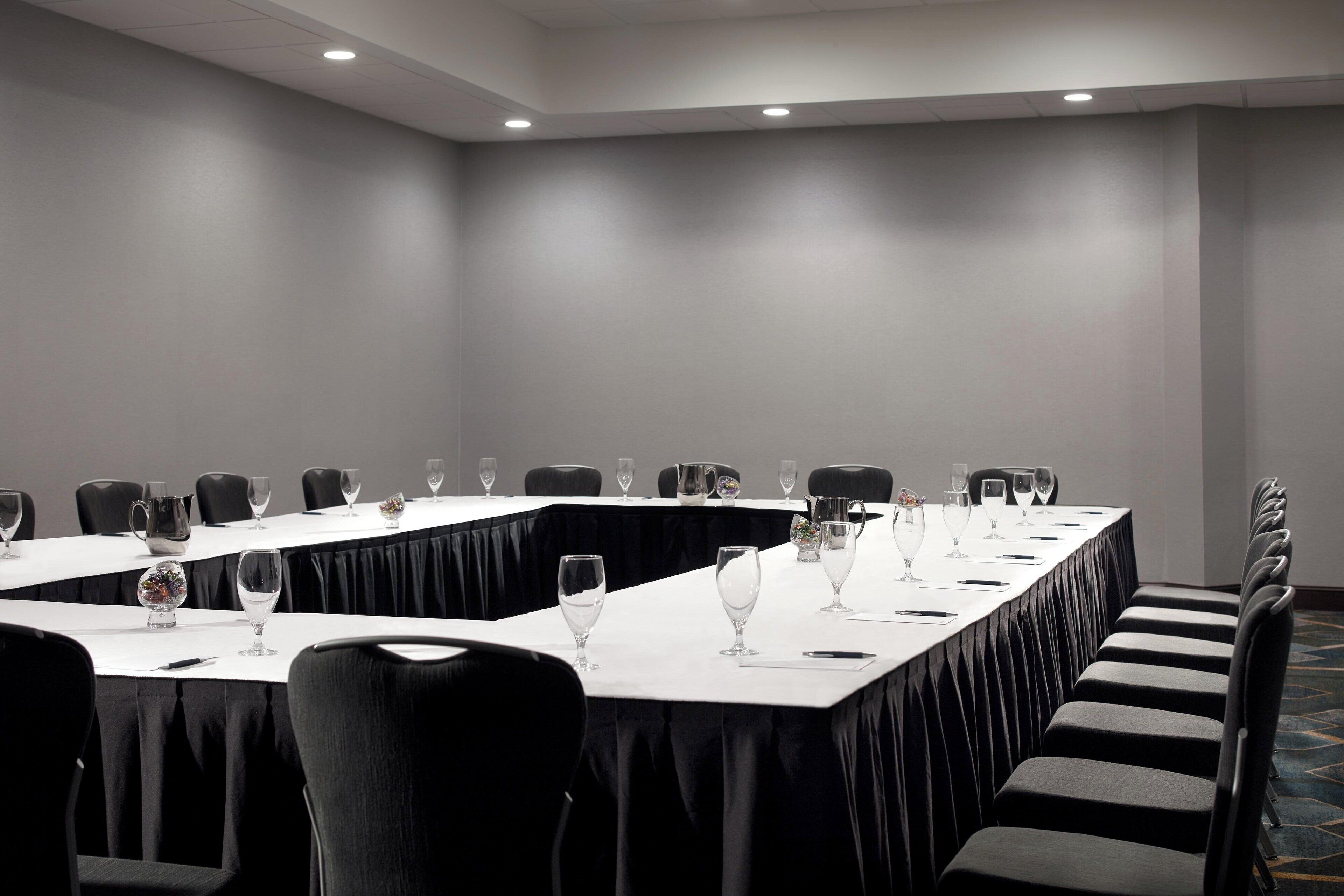 A conference room with a long table, chairs, and glassware.