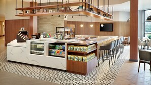 Eine moderne Bar mit einer Theke, Sitzgelegenheiten und einer Auswahl an Snacks.