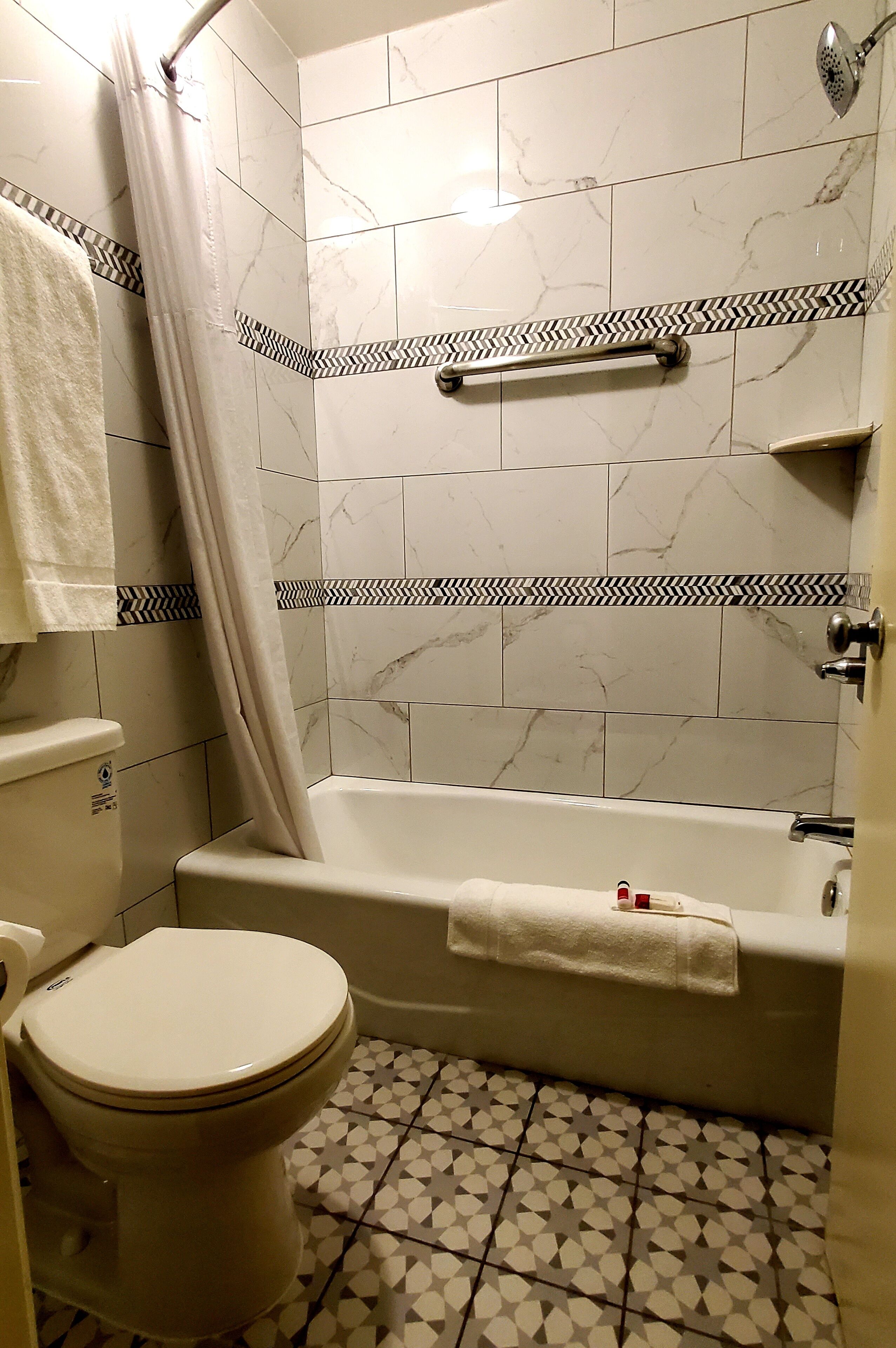 A bathroom with a toilet, bathtub, and shower curtain.