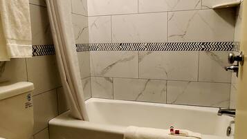 A bathroom with a toilet, bathtub, and shower curtain.