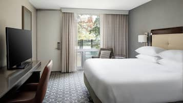 A hotel room with a bed, a TV, a desk, and a chair.